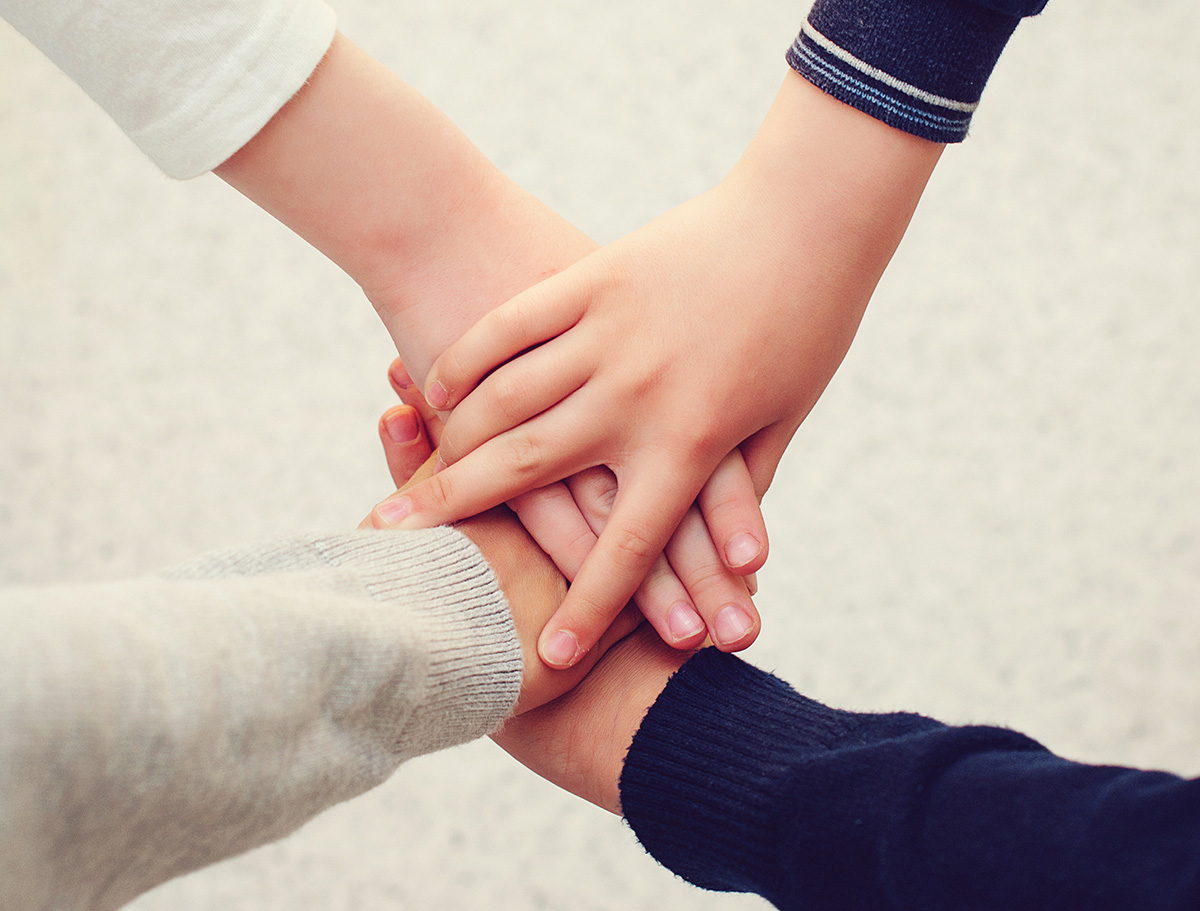 Hände von zwei Jungen treffen sich und liegen aufeinander